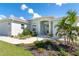 Charming single-story home featuring manicured landscaping, a light blue exterior, and a welcoming front entryway at 180 Rotonda N Blvd, Rotonda West, FL 33947