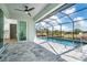 Screened-in pool area with a sparkling pool, tiled patio, and views of the surrounding landscape at 180 Rotonda N Blvd, Rotonda West, FL 33947