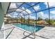 Beautiful screened-in pool with a tiled deck and view of lush landscaping at 180 Rotonda N Blvd, Rotonda West, FL 33947