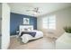 Bright bedroom with a ceiling fan, blue accent wall, and white queen-size bed at 2213 Oleada Ct, Englewood, FL 34224