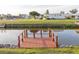 Wooden dock on a tranquil canal, surrounded by green lawns and nearby homes at 6113 Partridge Ave, Englewood, FL 34224