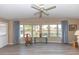 Bright living room with a ceiling fan, large windows, and stylish flooring at 6113 Partridge Ave, Englewood, FL 34224