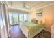 Bright bedroom featuring a queen bed, balcony access, and a ceiling fan at 2255 N Beach Rd # 9, Englewood, FL 34223