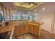 Kitchen with wooden cabinets, brown countertops, and views of the living area and balcony at 2255 N Beach Rd # 9, Englewood, FL 34223