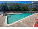 A community pool with red lounge chairs surrounded by palm trees at 2255 N Beach Rd # 9, Englewood, FL 34223