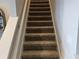 Carpeted staircase with neutral-toned carpeting and white risers at 16383 S Port Harbor Blvd, Port Charlotte, FL 33953