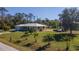 Single story home with spacious yard, palm trees and flagpole at 445 Stewart St, Englewood, FL 34223