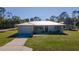 Single story home with metal roof, driveway and grassy lawn at 445 Stewart St, Englewood, FL 34223