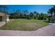 Large grassy yard with brick walkway and landscaping at 445 Stewart St, Englewood, FL 34223