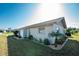 White house exterior with nicely landscaped yard and a shower at 5826 Harrison Rd, Venice, FL 34293