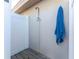 Convenient outdoor shower with wooden deck and blue towel at 5826 Harrison Rd, Venice, FL 34293