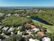 Aerial view of the property showcasing its location near a lake, golf course, and surrounded by lush trees at 3117 Silkwood Ln, Port Charlotte, FL 33953