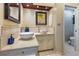 Bathroom featuring dual sinks with tile countertops, dark-framed mirrors, and a toilet in an adjacent room at 3117 Silkwood Ln, Port Charlotte, FL 33953