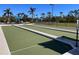 Bocce ball court with palm trees and blue shaded seating area in a well-maintained park setting at 3117 Silkwood Ln, Port Charlotte, FL 33953