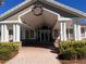 Inviting clubhouse entrance with wreath, brick walkway, and well-maintained landscaping at 3117 Silkwood Ln, Port Charlotte, FL 33953