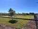 Community dog park enclosed with secure fencing, featuring green space and play structures for pets at 3117 Silkwood Ln, Port Charlotte, FL 33953