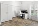 Home office with white desk, rolling chair, two monitors, cabinets and plank flooring at 3117 Silkwood Ln, Port Charlotte, FL 33953