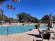 Resort-style pool area with palm trees, lounge chairs, and a clear blue sky on a sunny day at 3117 Silkwood Ln, Port Charlotte, FL 33953