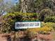 Community signage for Riverwood Golf Club with lush landscaping and stone accents at 3117 Silkwood Ln, Port Charlotte, FL 33953