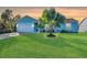 Light blue house with a white garage door and a lush green lawn at 2251 Meetze St, Port Charlotte, FL 33953