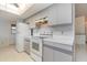 Kitchen with grey cabinets and white appliances at 4106 Library St, Port Charlotte, FL 33948