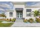 Inviting front entrance with a double light blue door, complemented by stone accents and lush landscaping at 8198 Clyde Cir, Port Charlotte, FL 33981