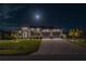 Night view of home's front exterior, showcasing a well-lit facade, two-car garage and a paver driveway at 8198 Clyde Cir, Port Charlotte, FL 33981