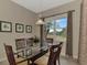 Bright dining room features glass table, wood chairs, and view of lush landscape at 13241 Creekside Ln, Port Charlotte, FL 33953