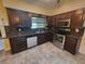 Kitchen with dark wood cabinets, granite counters, and stainless steel appliances at 1329 Sheehan Blvd, Port Charlotte, FL 33952