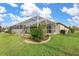 Landscaped backyard with pool and screened enclosure at 171 Medalist Rd, Rotonda West, FL 33947