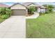 House exterior showcasing a two-car garage and well-manicured lawn at 171 Medalist Rd, Rotonda West, FL 33947