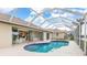 Relaxing kidney-shaped pool with a screened enclosure and patio furniture at 171 Medalist Rd, Rotonda West, FL 33947