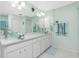 Bright bathroom with double vanity, glass sinks, and light green walls at 409 Boundary Blvd, Rotonda West, FL 33947