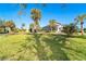 Large backyard with grassy area, palm trees, and a partially visible home at 4678 Arlington Dr, Placida, FL 33946