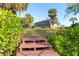 Wooden steps leading to a waterfront property with lush landscaping at 4678 Arlington Dr, Placida, FL 33946