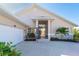 Tan house with white garage door, screened entryway, and landscaping at 4678 Arlington Dr, Placida, FL 33946