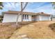 White single story home with brown roof, gravel driveway and mature landscaping at 560 Sandlor Dr, Englewood, FL 34223