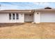 Front view of a renovated home with a white exterior, double doors, and a garage at 560 Sandlor Dr, Englewood, FL 34223