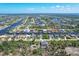 Aerial view of house and surrounding neighborhood with canal access at 15625 Melport Cir, Port Charlotte, FL 33981