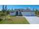 Contemporary home with white facade, gray roof, and spacious driveway at 15625 Melport Cir, Port Charlotte, FL 33981