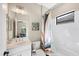 Clean bathroom with white vanity, tub shower combo, and patterned shower curtain at 26812 Pavin Dr, Englewood, FL 34223