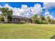 Single-story home with a large backyard and lush landscaping at 26812 Pavin Dr, Englewood, FL 34223