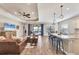 Open concept living room and kitchen with hardwood floors and brown leather sofa at 26812 Pavin Dr, Englewood, FL 34223