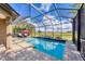 Screened-in pool area with a red umbrella and open views of the backyard at 26812 Pavin Dr, Englewood, FL 34223