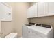 Bright laundry room with washer, dryer, and upper cabinets at 2759 Lavandula Ct, North Port, FL 34289