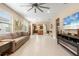 Open living room, tile floors, kitchen view, ceiling fan at 2759 Lavandula Ct, North Port, FL 34289