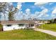 White house with carport, landscaping, and driveway at 3265 Smith St, Englewood, FL 34224