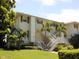 White two-story building with stairs and palm trees at 5850 Gasparilla Rd # M7, Boca Grande, FL 33921