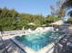 Community pool with plenty of lounge chairs and umbrellas at 5850 Gasparilla Rd # M7, Boca Grande, FL 33921