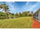 Landscaped backyard with canal and palm trees at 7297 Jennifer Dr, Port Charlotte, FL 33981